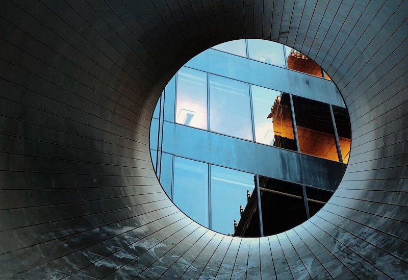 Image of looking through a circular tunnel towards an office building