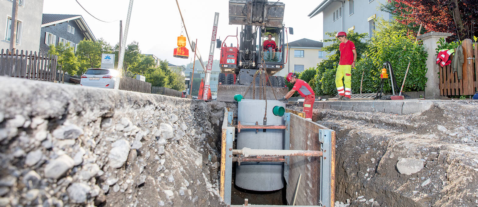 Hochbau Tiefbau Strassenbau Mitarbeiter des Strassenbaus versetzen einen Schacht in den Boden.