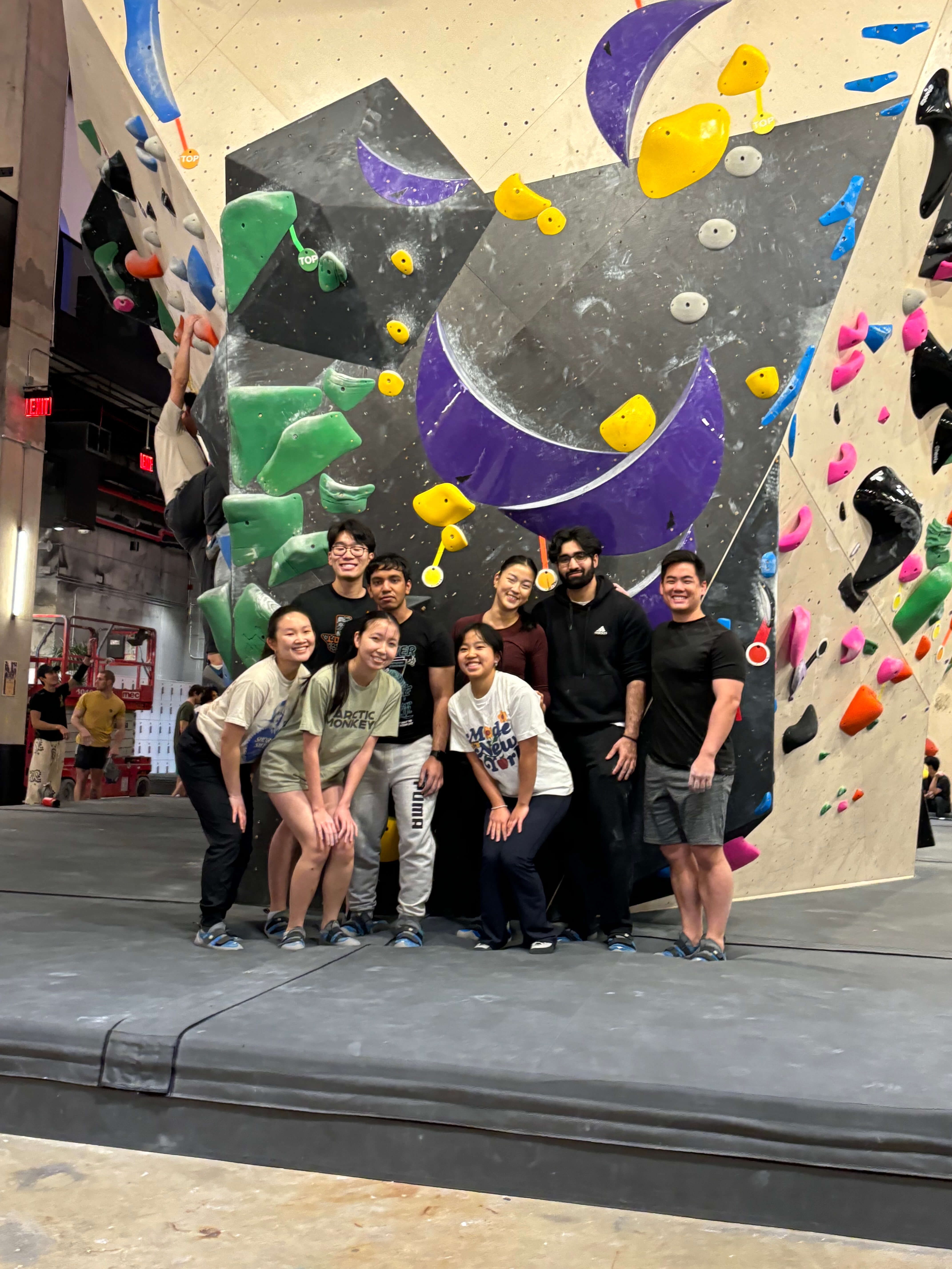 Group of Rippler's posing in front of a climbing wall.