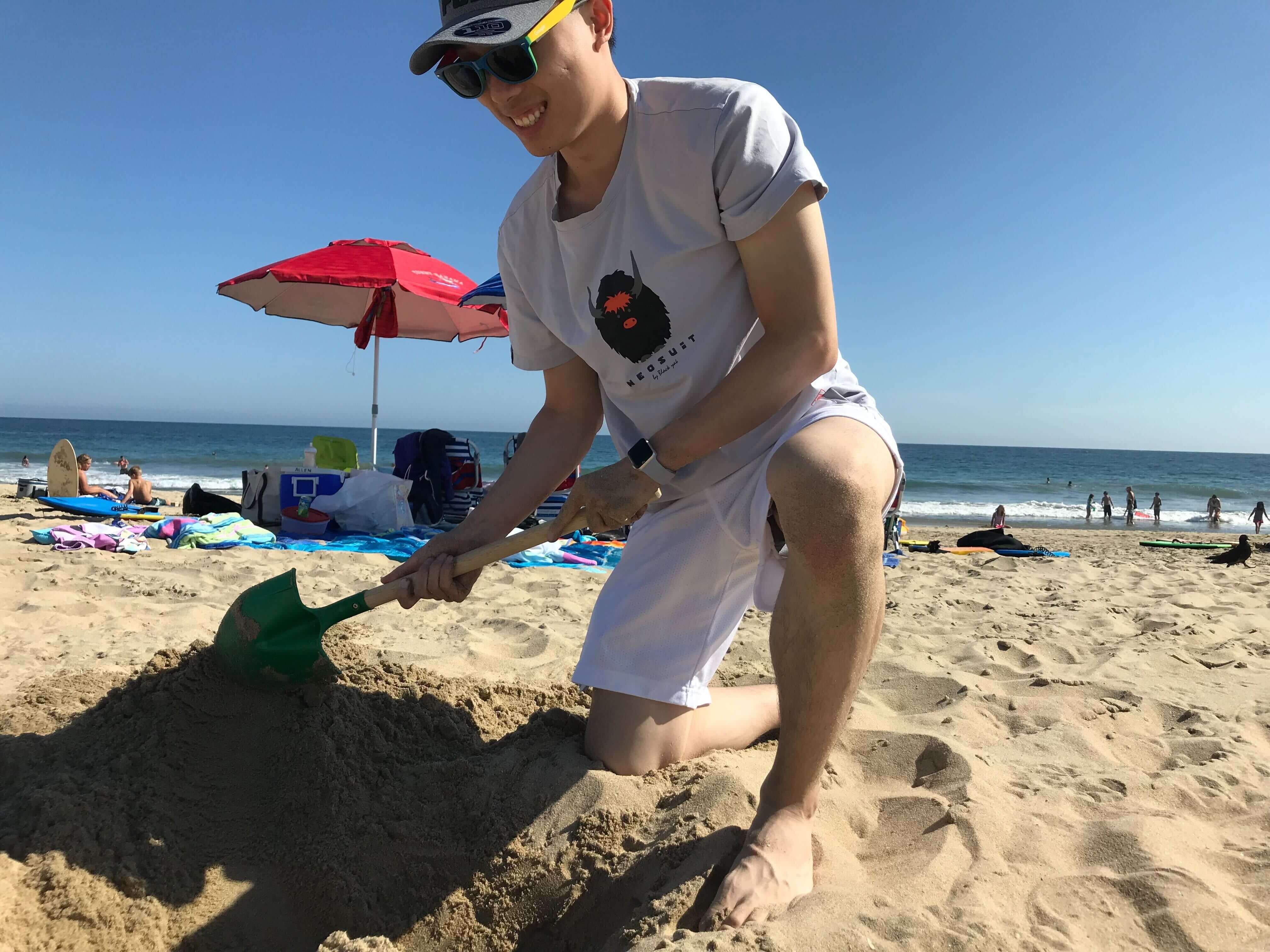 Jihai Xu at the beach digging.