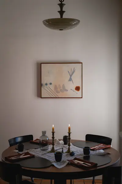 Table is adorned with a vintage lace textile from Josie's collection, Peter Speliopoulos Placemats and Napkins, JB Blunk Cups, Lisa Eisner Candle Snuffer, and Carafe by R+D Lab. The painting, titled "Diana" is by Dan Bruinooge.