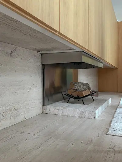 The travertine void under the paneled primavera expanse actually creates the travertine counter fronts and tops in both bathrooms.