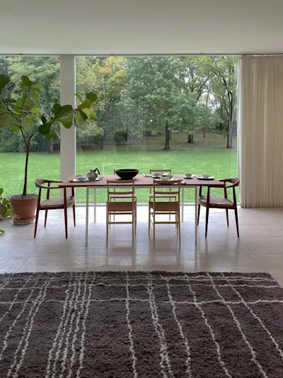 Expansive rugs layer over the perfect grid of travertine flooring.