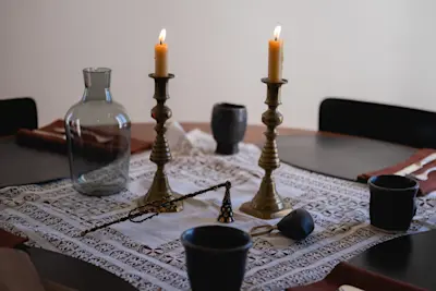 Table is adorned with a vintage lace textile from Josie's collection, Peter Speliopoulos Placemats and Napkins, JB Blunk Cups, Lisa Eisner Candle Snuffer, and Carafe by R+D Lab.