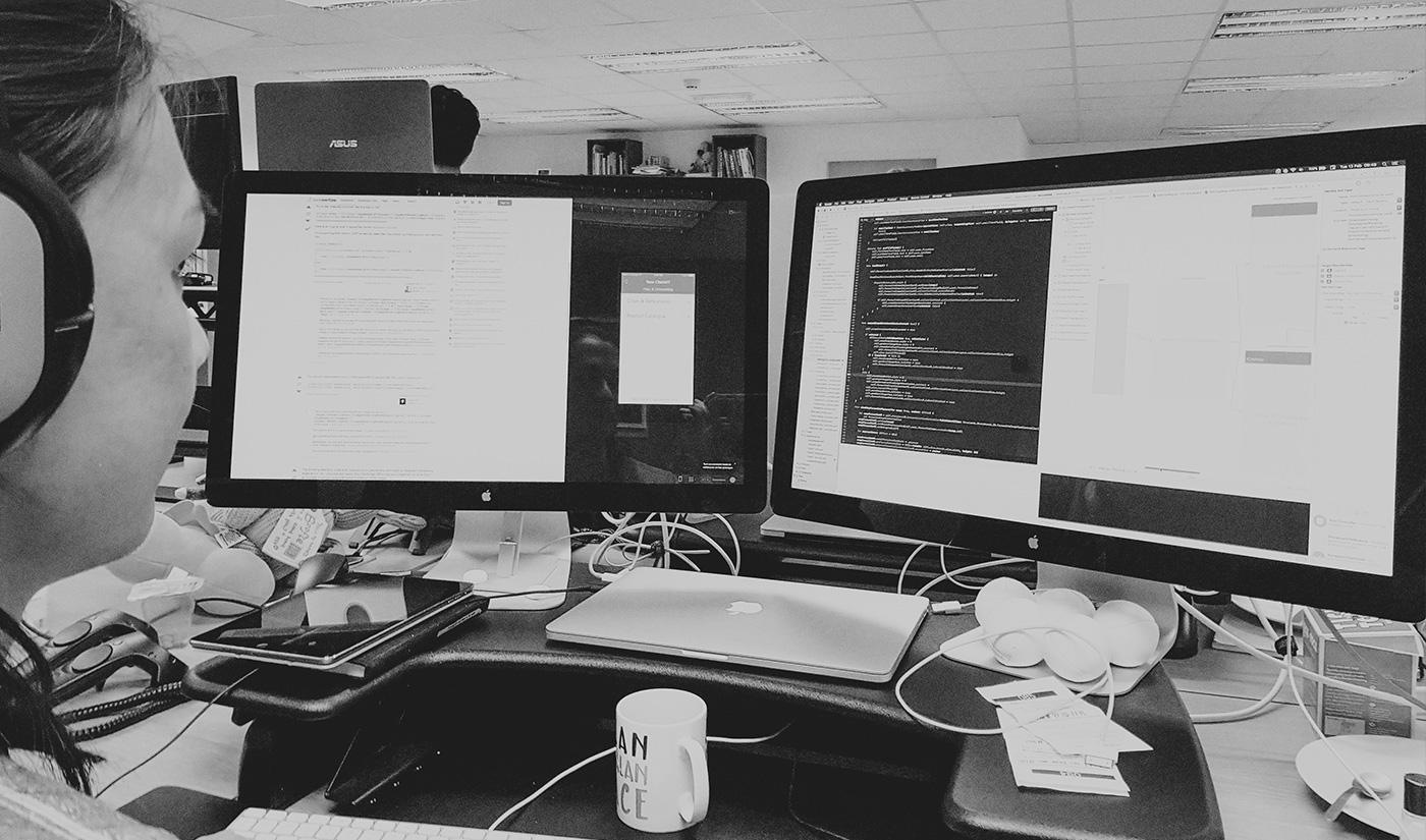 A person sat at their desk wearing headphones doing web development