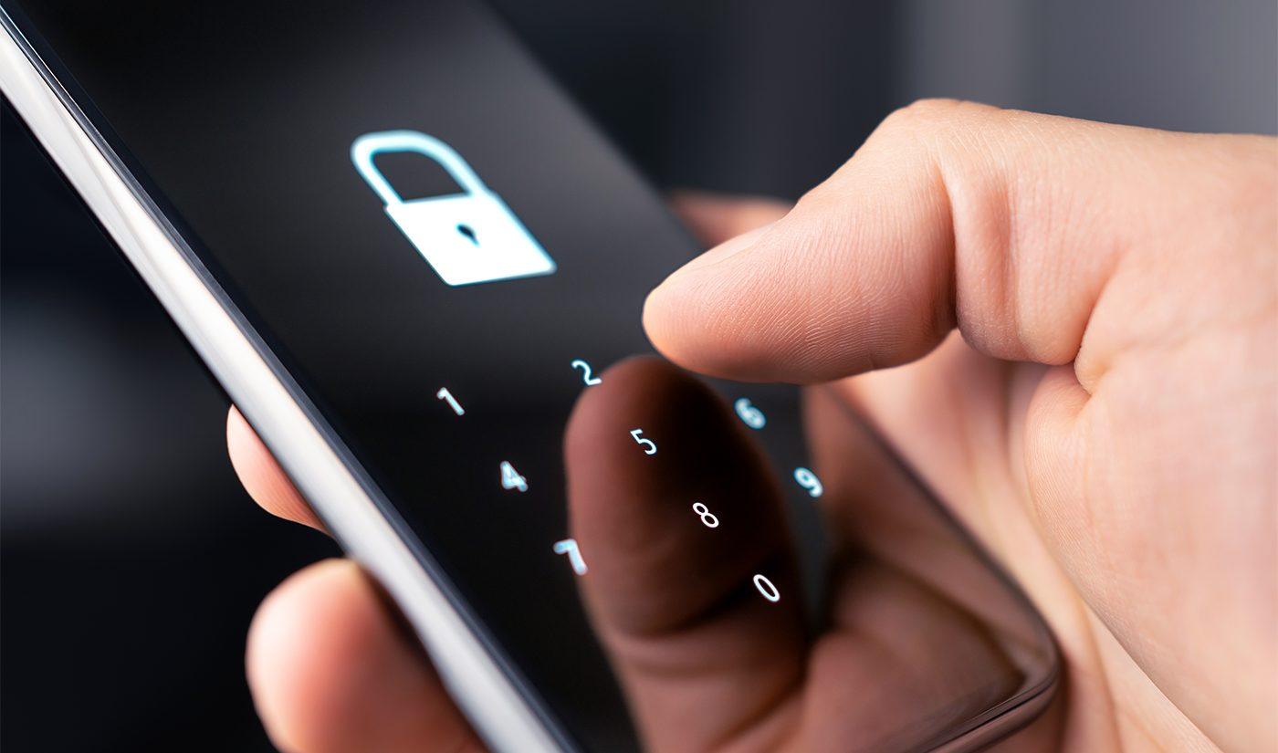 Someone holding a phone about to type in a passcode to unlock it.