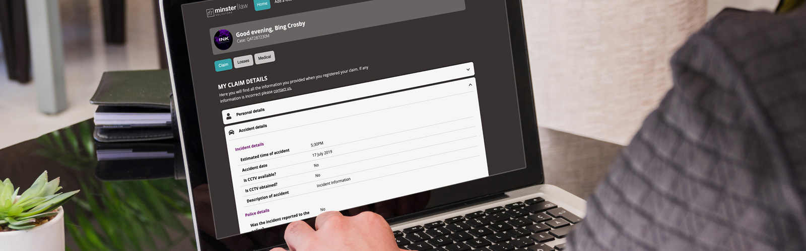 Someone sat at their desk using a laptop to edit their details on the Minster Law customer claims portal
