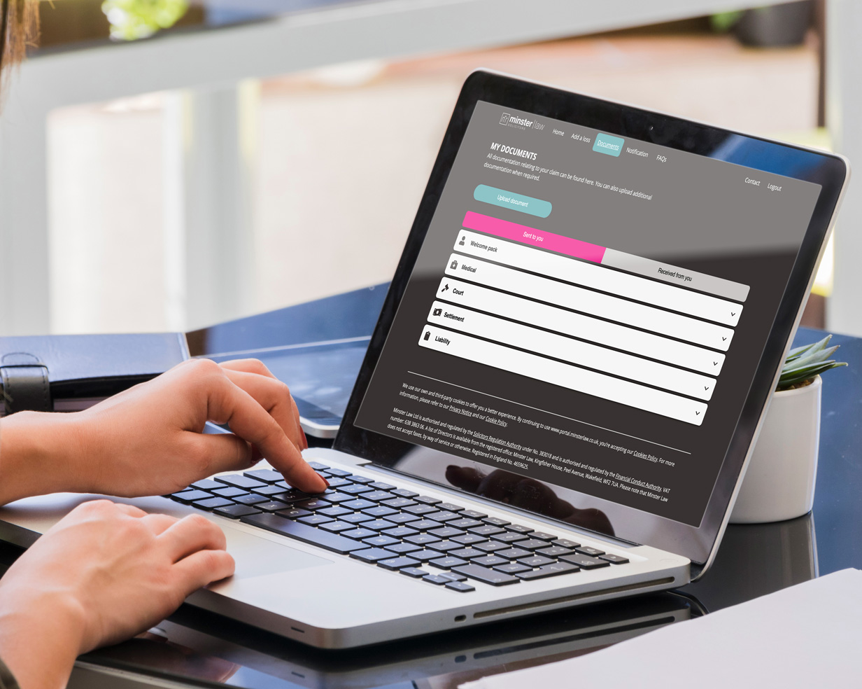Someone inputting details into the Minster Law Claims customer portal on a laptop