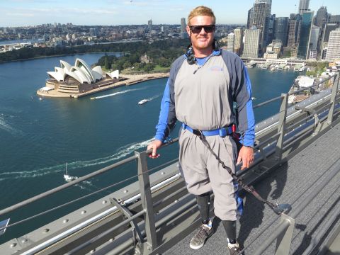 Jade ‘Red’ Wheatley, pro-adaptive surfer, and organiser of Walk for Waves at the summit of the Sydney Harbour Bridge. Image: BridgeClimb