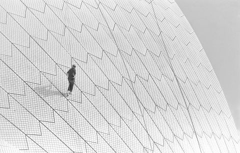Enjoying a moment on the sails, a lone worker abseils down the curve of an icon. Photo: Tim Cole, City of Sydney Archives, A-00083474.