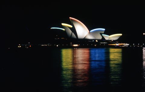 The 2000 Olympics, a glorious time to be a Sydneysider indeed, saw the sails lit with the Olympic colours. Photo: C. Moore Hardy, City of Sydney Archives - A-00075168.