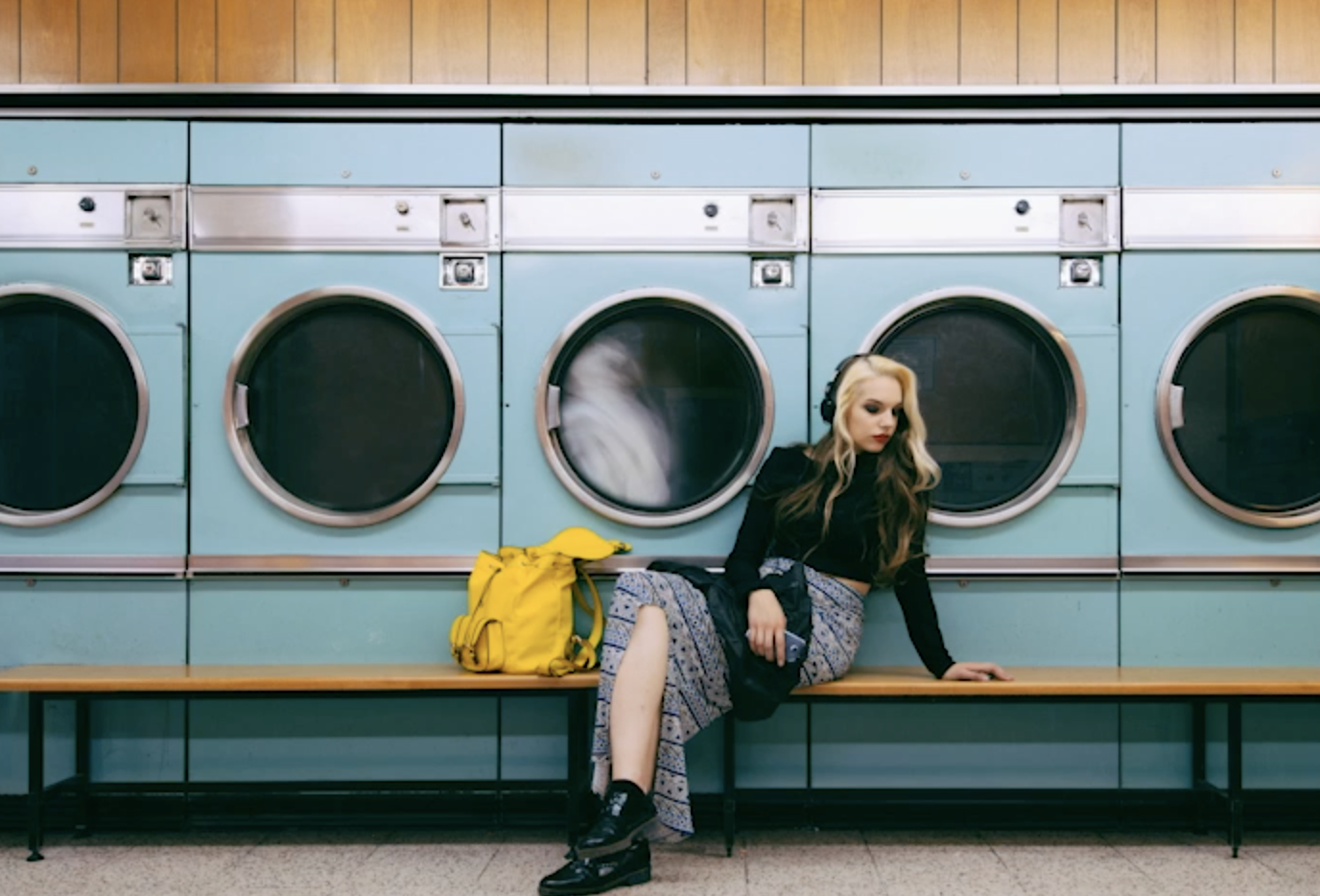 Woman waiting for laundry at launderette cinemagraph seamless loop 