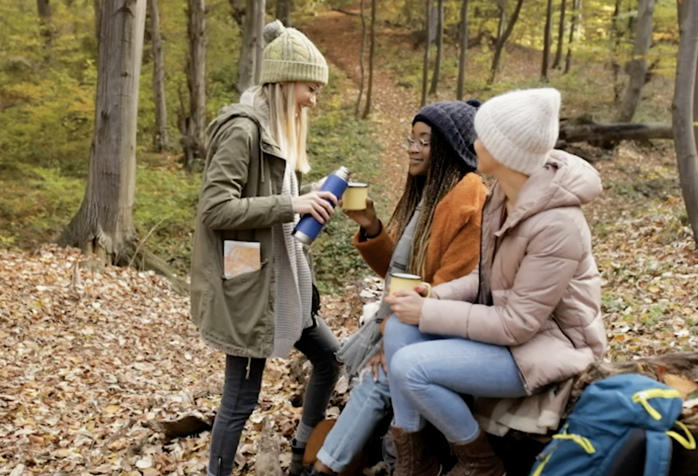 Three female friends having fun and enjoying hiking in forest.
