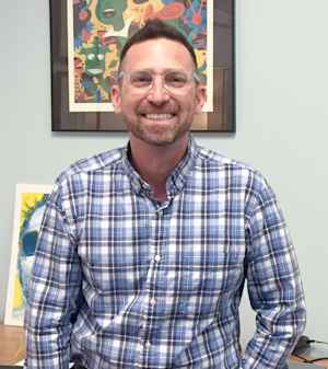 Gerard Ilaria of Headstrong wears glasses and smiles