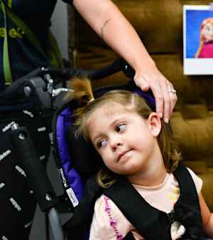 A mother caresses her young daughter's hair while they waits for the appointment to begin.