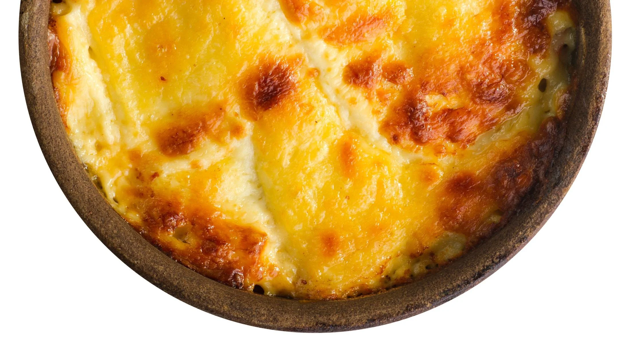 A round rustic baking dish with a golden, bubbly cheese-topped eggs, browned in spots, on a white background.