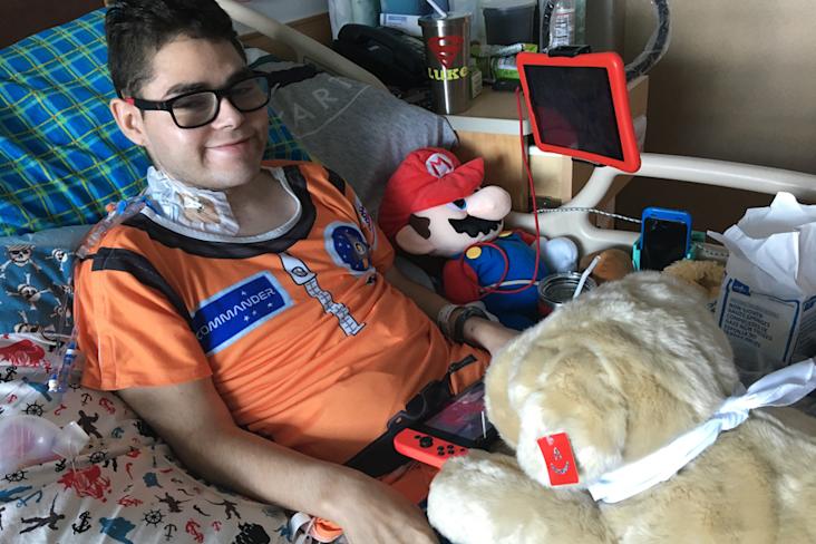 Starlight kid luke laying in the hospital with his dog