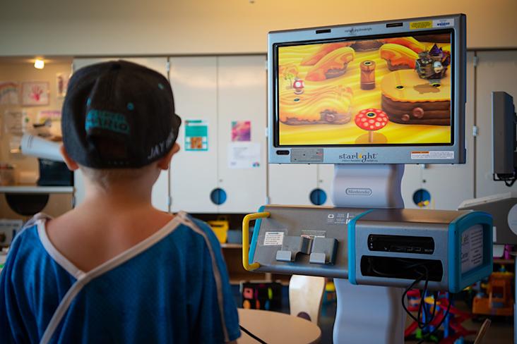 Starlight kid Jay playing on a Starlight gaming console