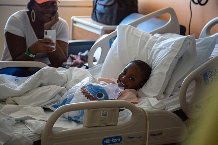 boy in hospital bed with small baby shark stuffed animal