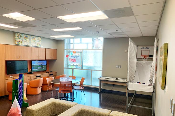 Updated Teen Room at Dell Children's Medical Center with basketball hoop game, couches, T.V.s and computers