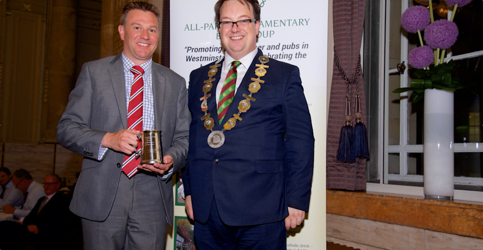 (l-r): Chris Soley, chief executive of Camerons Brewery, collects the Corporate Charity Fundraiser 2019 trophy from Mike Wood, chair of the All-Party Parliamentary Beer Group