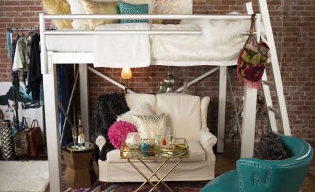 A high angle shot of a full size Adult Loft Bed with a cream colored love seat under it.
