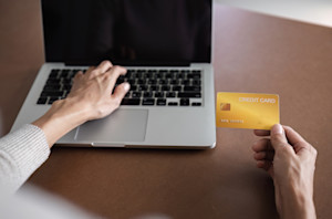 Femme qui paye avec sa carte bleu sur son ordinateur