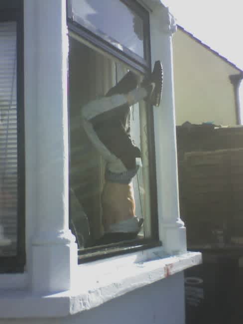 burglar stuck in window hanging down