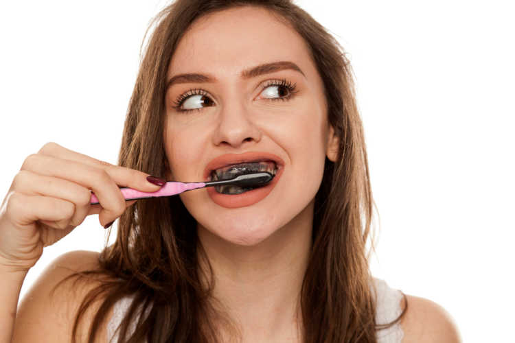 brushing teeth with Activated Charcoal toothpaste