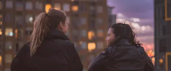 Två kvinnor pratar Två kvinnliga vänner som pratar