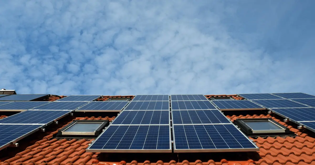 Solceller på hustak Solceller på tegelhustak med blå himmel i bakgrunden