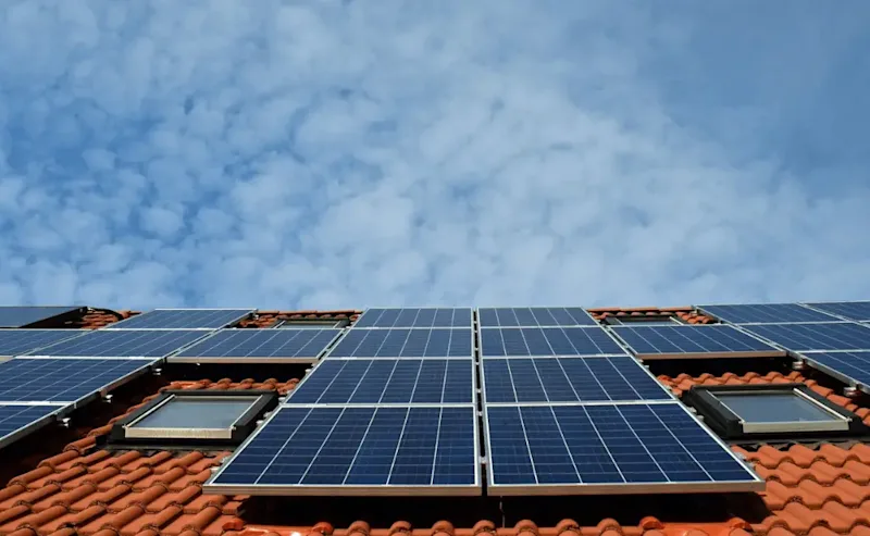 Solceller på hustak Solceller på tegelhustak med blå himmel i bakgrunden