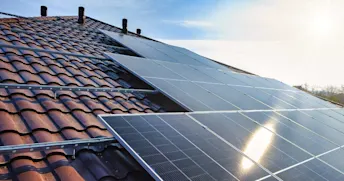 solceller-tak.jpg Solceller i solljus på rött tegeltak.