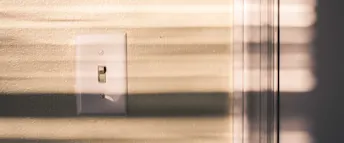 Lampknapp Vit lampknapp på en beige vägg