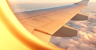 Flygplansfönster Utsikten från ett flygplansfönster med vit flygplansvinge och moln i bakgrunden