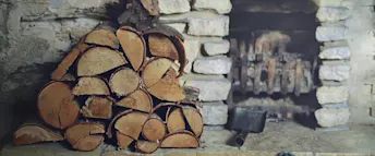 månadssparande staplad vedhög bredvid en öppen spis