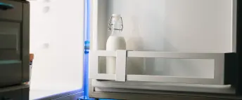 öppet kylskåp med en mjölkflaska
