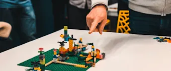bäst-betalda-jobben.png Man som pekar på lego som står på ett bord