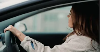tjänstebil Leende kvinna i profil kör bil.