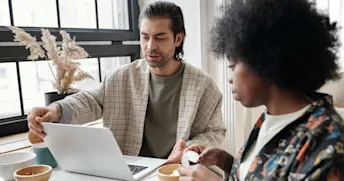 insurance company 2 Kvinna och man sitter och äter frukost medan mannen arbetar på sin laptop.