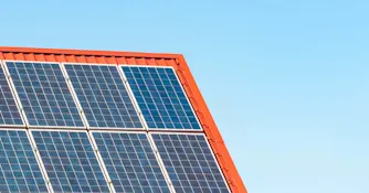 solceller-hustak.jpg Solceller på hustak med lertegelpannor och blå himmel i bakgrunden.