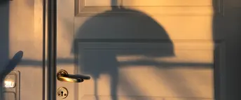 skuggan av en lampa på en vit dörr