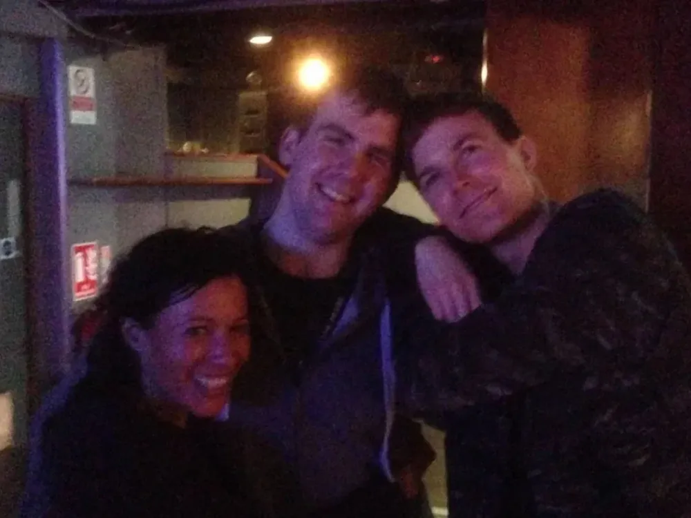 Our founder craig, standing hugging artists Matt and Kim at a concert