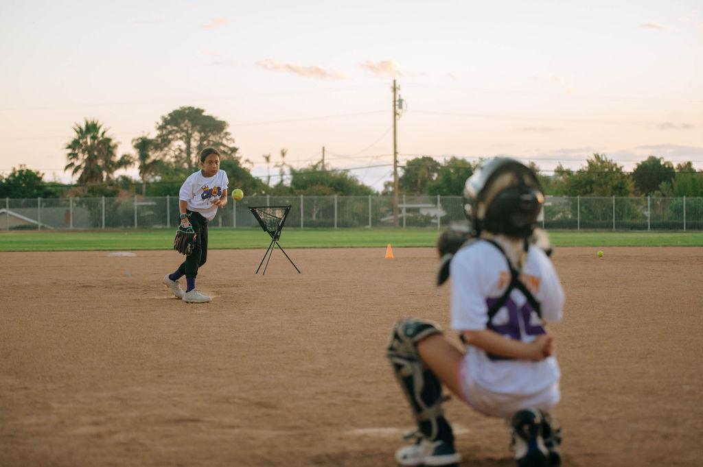 Girl pitching the ball to catcher