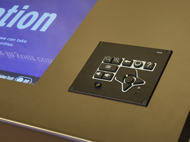 A close-up of a UXP-D mounted on a museum interactive, beside the edge of a touchscreen.