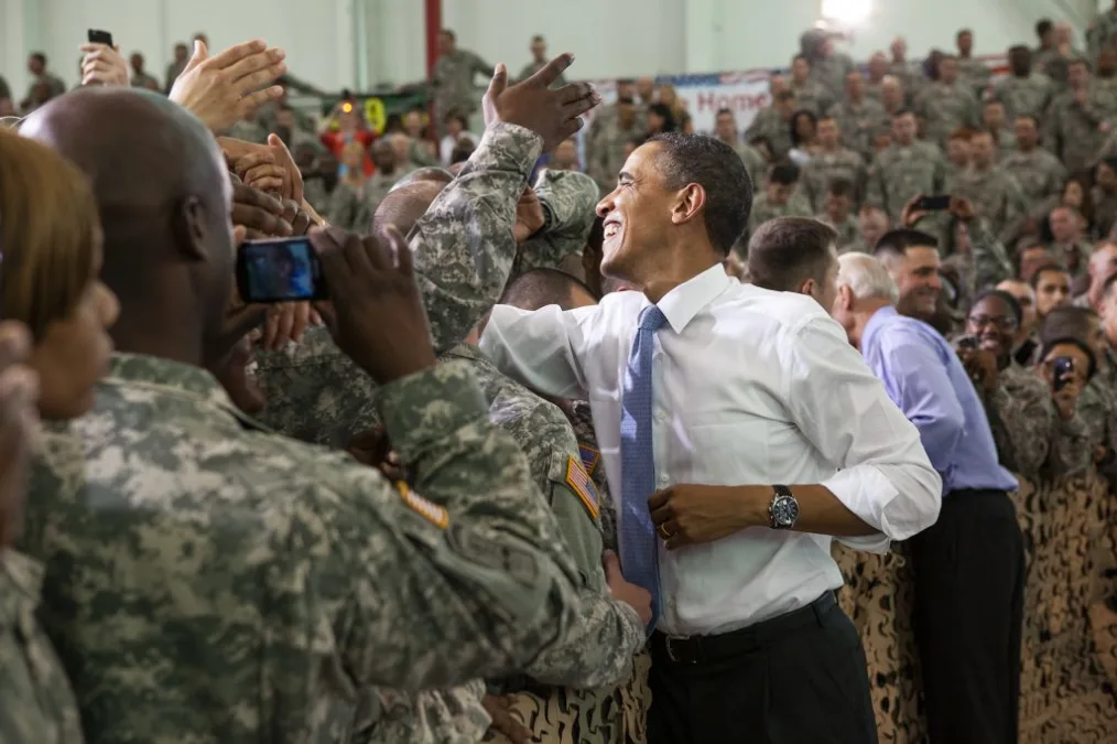 President Obama reaches to shake hands with a cheering crowd of American soldiers.