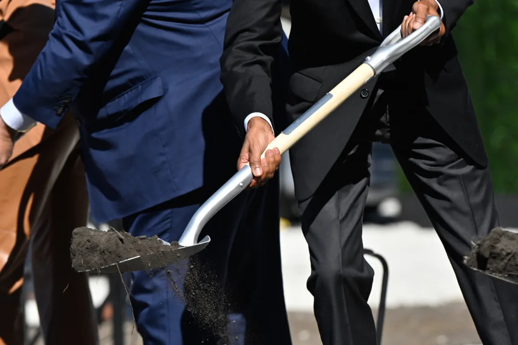 President Obama hands holding a shovel, moving dirt.