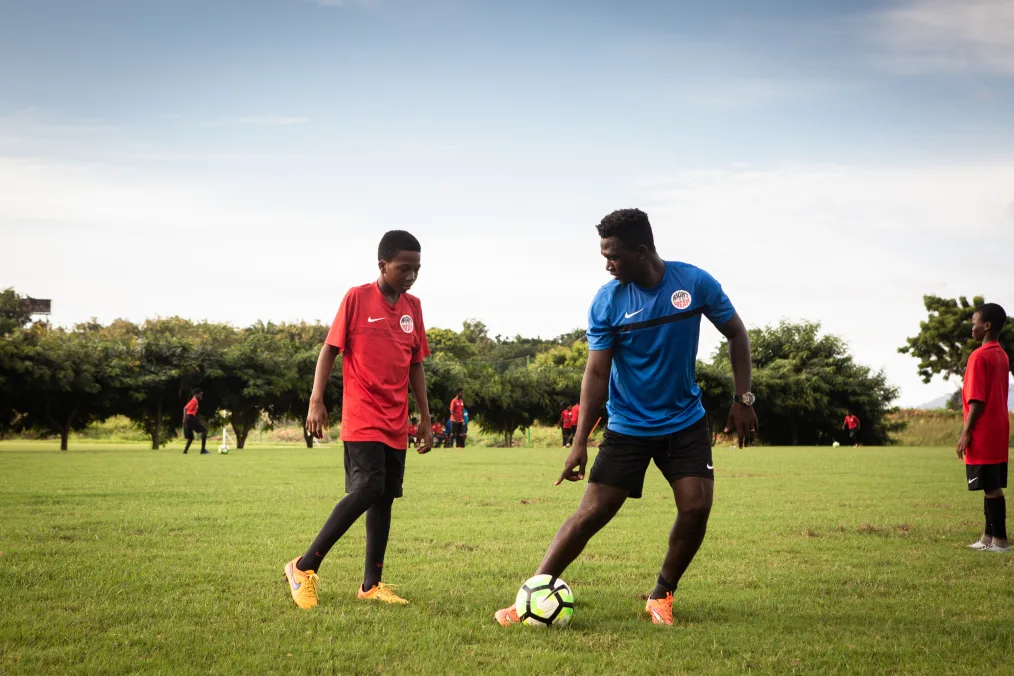King Gyan plays soccer with one of his students. 