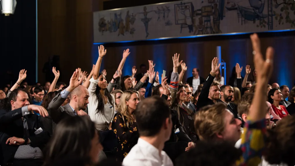 Attendees at a town hall in Berlin raise their hands, eager to discuss the future of Europe with President Obama.