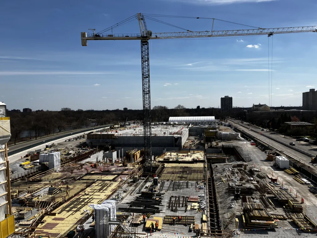 A massive crane stands high above a construction site.